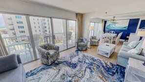 Ein modernes Hotelzimmer mit Balkon, einer Essecke und einem großen Fenster mit Blick auf die Stadt.