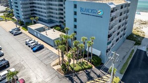 Un hotel de varios pisos con un letrero llamativo de resort y condominio frente a la playa.