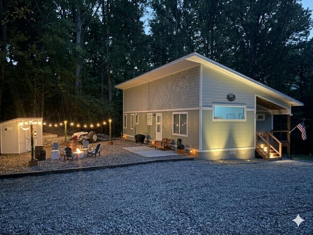 A two-story building with a covered porch, a small shed, and outdoor seating.