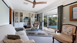 A living room with a sofa, armchair, and a television on a cabinet.