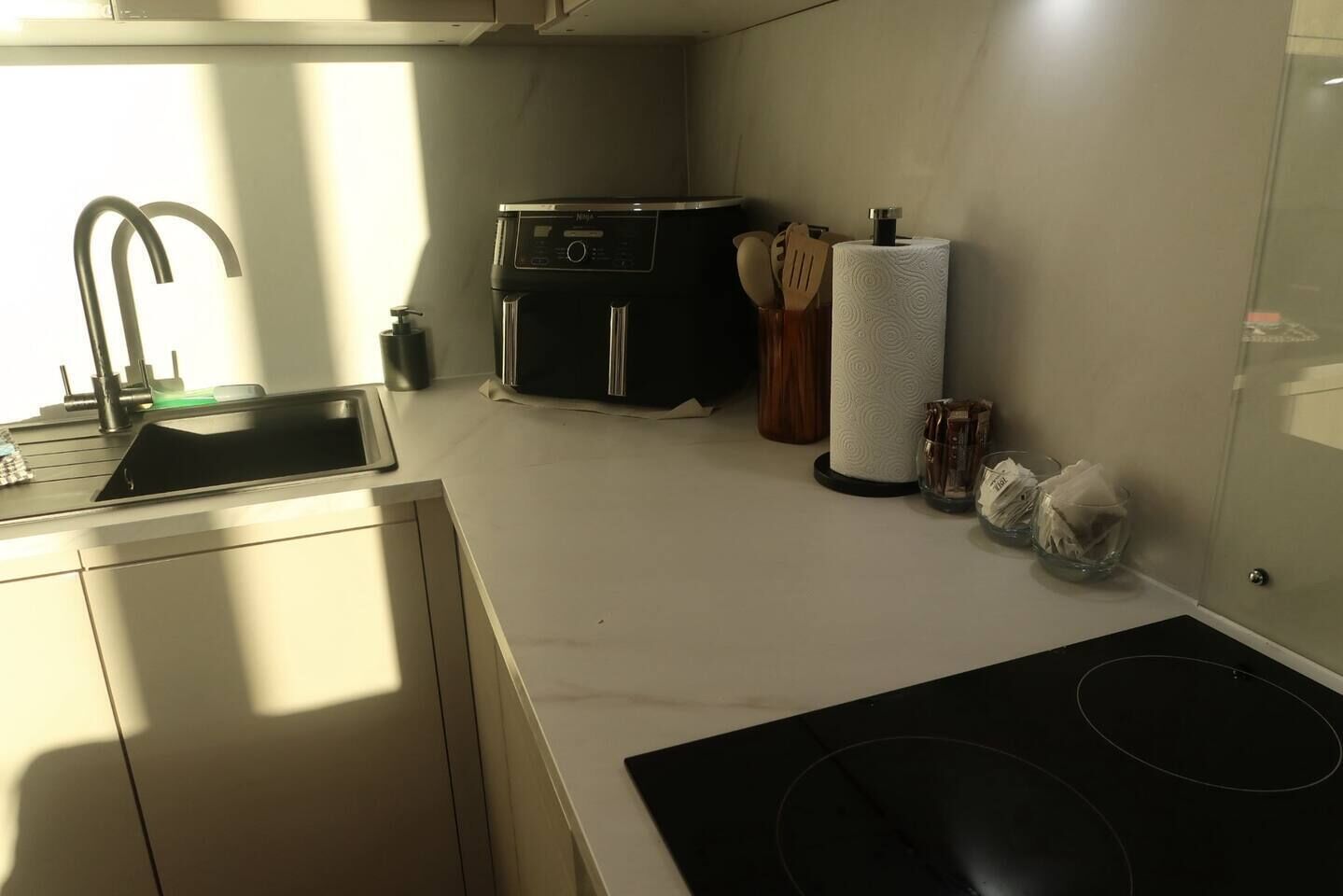 A modern kitchen with a sink, stove, and a microwave.