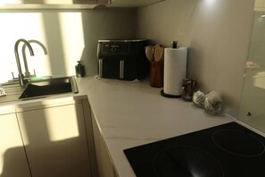 A modern kitchen with a sink, stove, and a microwave. - #132 Stylish Luxury Flat | Free Parking |City View (Merseyside)