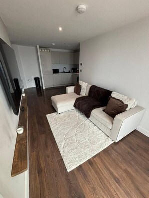 A modern living room with a sofa, a coffee table, and a rug. - #132 Stylish Luxury Flat | Free Parking |City View (Merseyside)