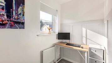 Ein moderner Arbeitsbereich mit Schreibtisch, Computer und Stauraum.