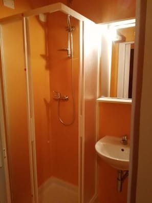 A bathroom with a shower, a sink, and a mirror. - Hotel Simon (Rimini)