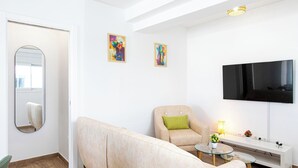 Een moderne woonkamer met een bank, fauteuil en een glazen salontafel.