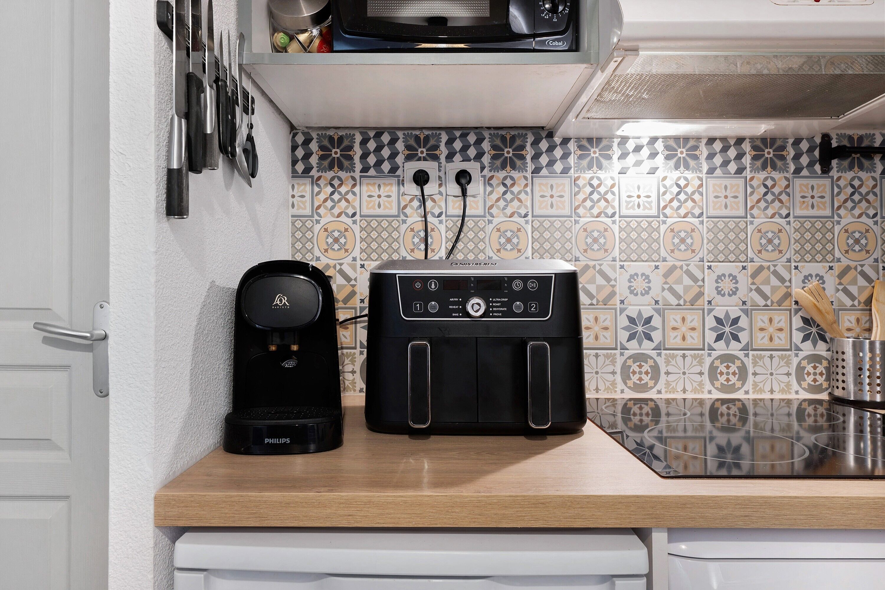 Une cuisine équipée d’une machine à café, d’un grille-pain et d’un crédence décorée.