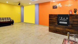 Zona de recepción con mostrador, un reloj y un extintor en la pared.