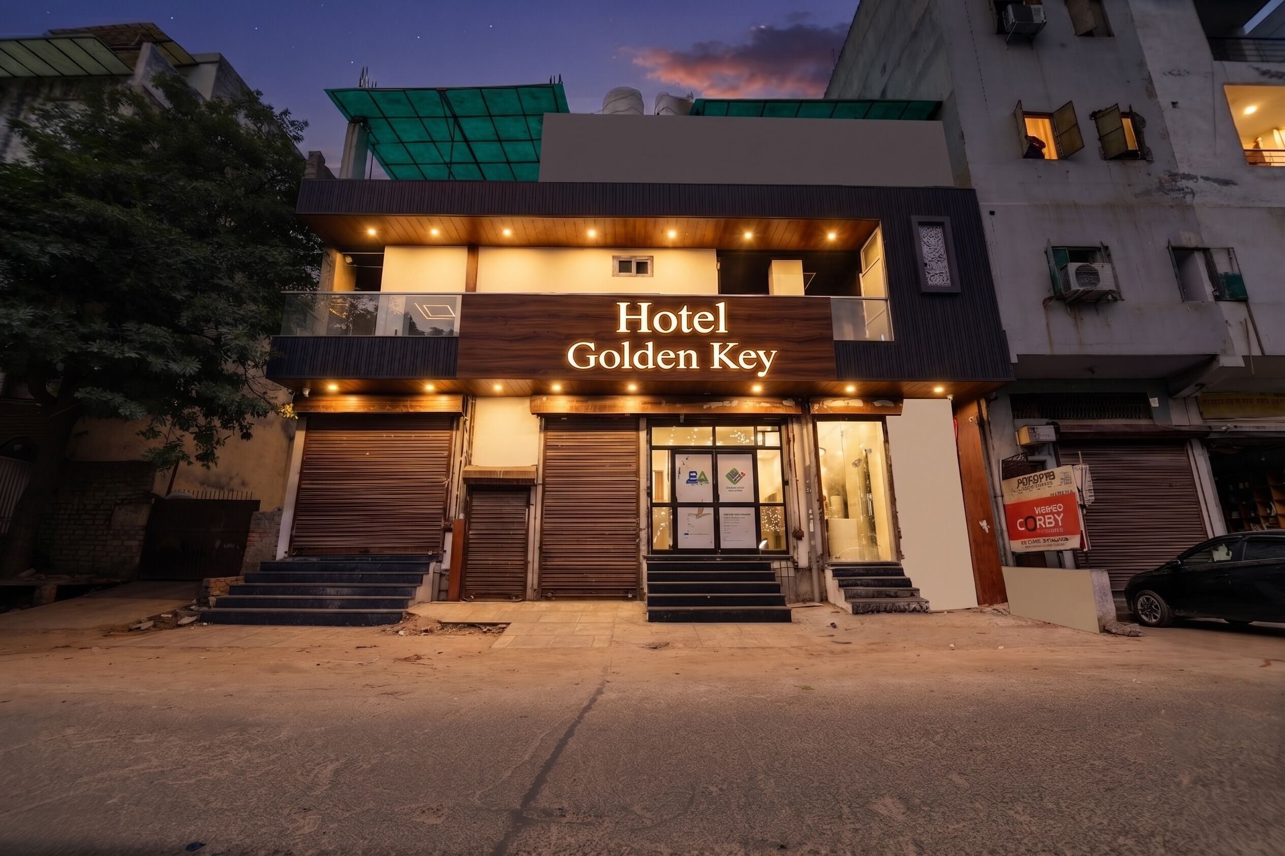 Un hotel llamado 'Hotel Golden Key' con una fachada moderna, varios accesos y una escalera visible que conduce a la entrada.