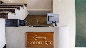 A reception desk with a Lenovo monitor, keyboard, and mouse. A wooden plaque with a key design and the words 'Golden Key' is mounted on the desk. - Golden Key - Badli Near Rohini Sec 18- 19 Metro (New Delhi)