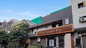 A hotel named 'Hotel Golden Key' with a modern facade, a green awning, and a staircase leading to the entrance. - Golden Key - Badli Near Rohini Sec 18- 19 Metro (New Delhi)