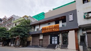 A hotel named 'Golden Key' with a modern facade, a green roof, and a visible entrance.