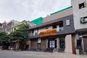 A hotel named 'Golden Key' with a modern facade, a green roof, and a visible entrance.