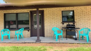 A building with a brick exterior, a front door, and a window. There are two outdoor chairs and a grill on the sidewalk. - Newly remodeled. Quiet neighborhood 4 blocks from iconic Sturgis mainstreet (Sturgis)