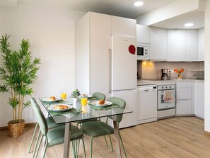 A modern kitchen with white cabinets, a microwave, a stove, and a refrigerator. - Elvix Nerja Centre B by Interhome (Nerja)
