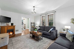 A living room with a fireplace, a sofa, a coffee table, and a television. - Cozy Getaway Near History, Hiking & Adventure (Bolivar)