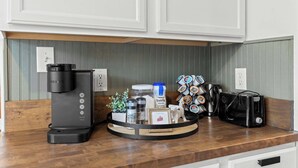 A kitchen counter with a coffee maker, a toaster, and a coffee grinder.