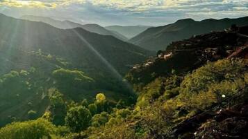 A mountainous landscape with a clear sky and sunlight.