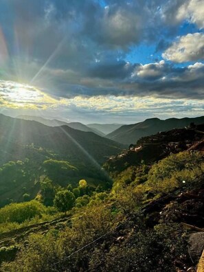 A mountainous landscape with a clear sky and sunlight.