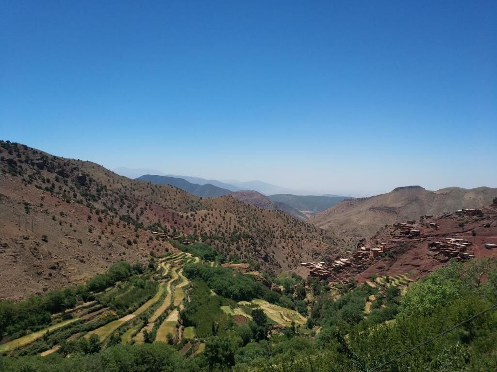Un paysage montagneux, avec des champs en terrasses et des bâtiments dispersés.