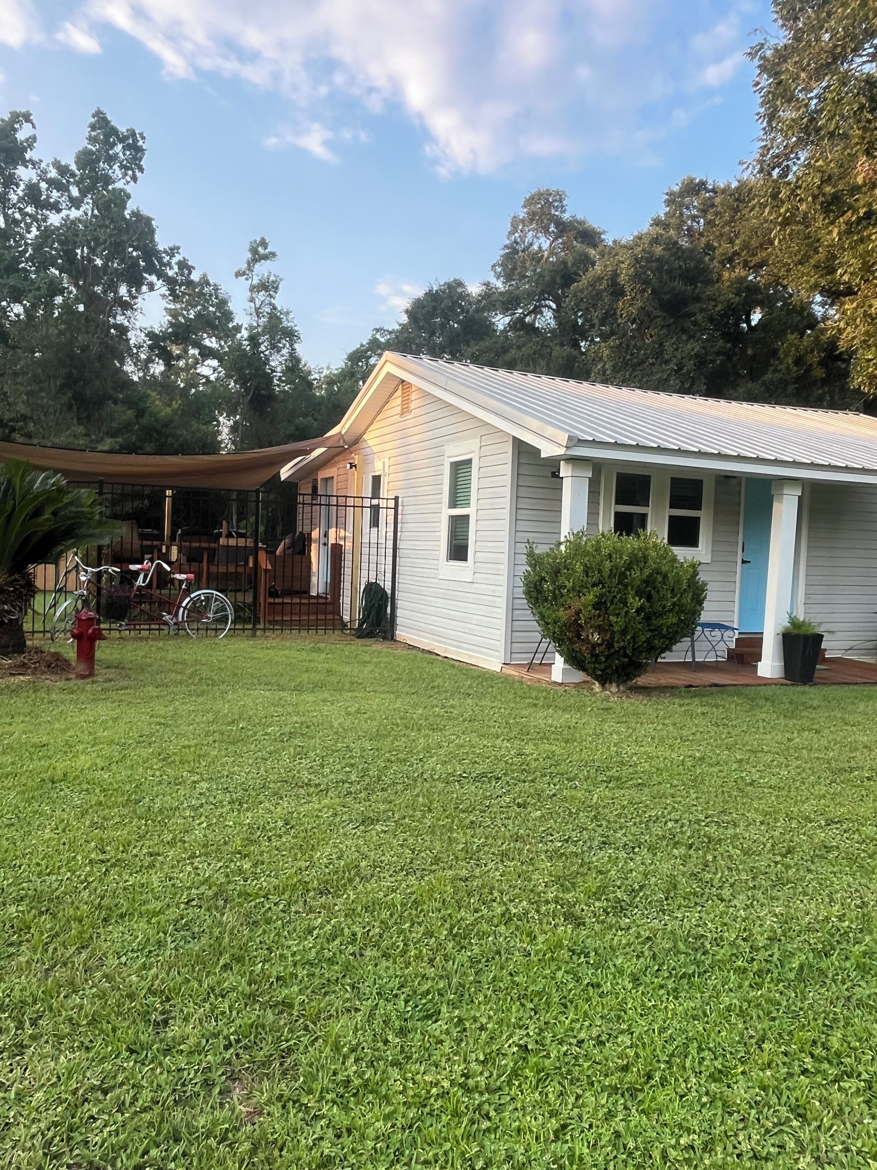 A single-story house with a front porch, a small front yard, and a bicycle parked outside.
