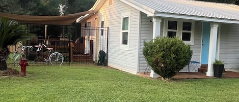 A single-story house with a front porch, a small front yard, and a bicycle parked outside.