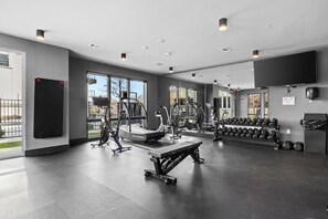 A gym with various exercise equipment, large windows, and a flat floor. - NEW! Chic Designer 2BR w/ Pool / Midtown Townhome (Nashville)