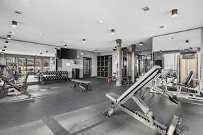 A gym with exercise equipment, a dumbbell rack, and a treadmill. - NEW! Chic Designer 2BR w/ Pool / Midtown Townhome (Nashville)