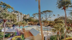 Ein Resort mit Pool, Palmen und Blick auf den Ozean.
