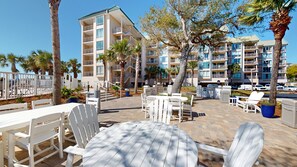 A resort with outdoor seating, palm trees, and a multi-story building with balconies. - Two Bedroom Second Floor Condominium with Pool and Ocean Views! (Hilton Head)