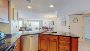 A spacious kitchen with a central island, wooden cabinets, and a dishwasher. - Two Bedroom Second Floor Condominium with Pool and Ocean Views! (Hilton Head)