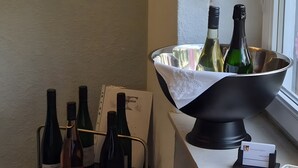 A room with a table holding wine bottles, a potted plant, and a decorative item. - Guesthouse 'Eifelglück' with Private Terrace, Garden, and Wi-Fi (Großlittgen)