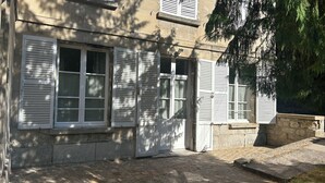 A building with a stone facade, multiple windows with shutters, and a stone staircase leading to the entrance. - LE REFUGE DU MOULIN - 2-Bedroom Apartment in Downtown Senlis (Parking) (Senlis)