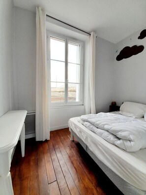 Ein Zimmer mit einem Bett, einem Schreibtisch und einem Fenster.