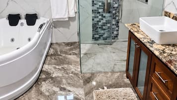 Une salle de bain moderne dotée d’une douche à parois de verre, d’une baignoire sur pieds et d’un meuble-lavabo.