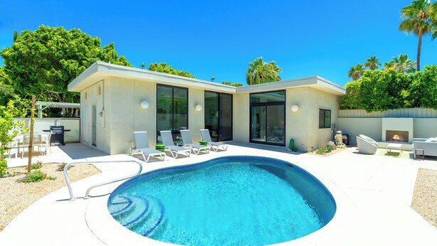 Uma casa moderna com piscina, área de estar externa e lareira.