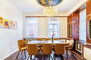 Ein Esszimmer mit einer Kandelaber, einem Tisch mit Stühlen und einem Gemälde an der Wand.