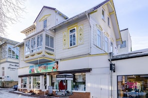 Ein mehrstöckiges Gebäude mit Schaufenster, das ein Schild für 'Abini' und ein Schild mit '30% Sale' zeigt.