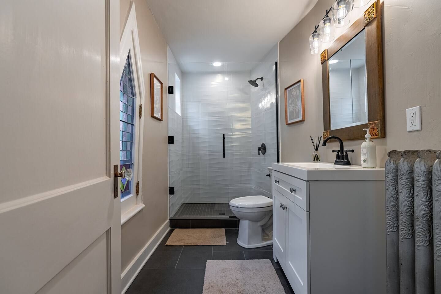 Een moderne badkamer met een douche, toilet en wastafel.