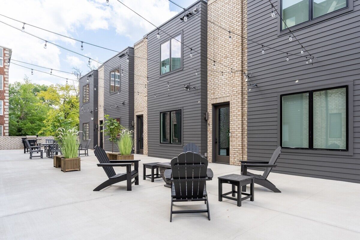 A modern outdoor patio with seating and potted plants.
