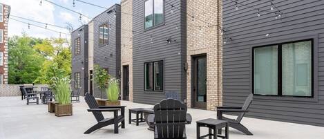 Eine moderne Terrassenanlage mit Sitzgelegenheiten und Topfpflanzen.