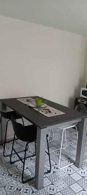 Ein Esstisch mit Stühlen, einer grünen Tasse und einer dekorativen Tischmatte.