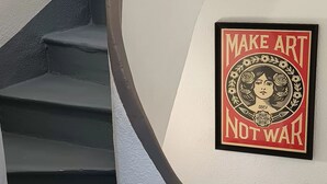 En trappe med gelænder og et ophængt skilt med teksten 'MAKE ART NOT WAR'.