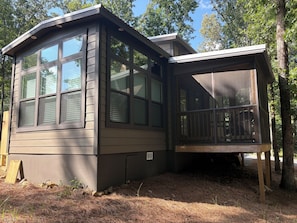 A cabin with a large windowed front section and a covered porch area. - Peaceful tiny home in cozy mentone (Mentone)