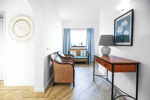 Un salon moderne avec un canapé, une table d’appoint et une lampe fixée au mur.