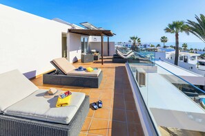 A rooftop terrace with outdoor seating, a glass balustrade, and a view of the sea and buildings. - Villa Cilla - Four Bedroom Villa, Sleeps 8 (Puerto del Carmen)