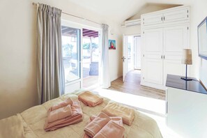 A bedroom with a bed, a desk, and a view of the outside. - Villa Cilla - Four Bedroom Villa, Sleeps 8 (Puerto del Carmen)