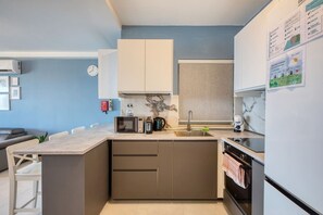 A compact kitchen with a microwave, toaster, and sink. - Modern Qawra Apartment with Sea View (St. Paul`s Bay)