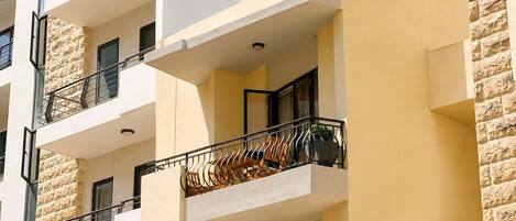 Un immeuble à plusieurs étages, doté de balcons, d’une façade en pierre et d’un toit plat.