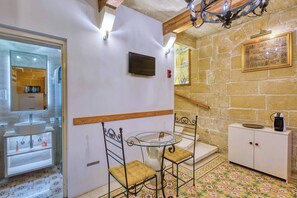 A bathroom with a sink, mirror, and shower area. - Charm Suite Valletta (Valletta)